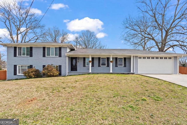 tri-level home with an attached garage, fence, concrete driveway, and a front yard