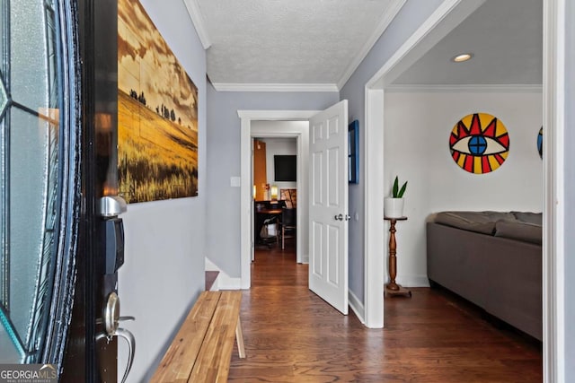 foyer entrance with a textured ceiling, baseboards, crown molding, and wood finished floors