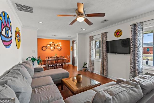 living area featuring visible vents, wood finished floors, and ornamental molding