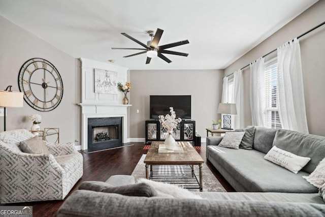 living room with ceiling fan, a fireplace, baseboards, and wood finished floors