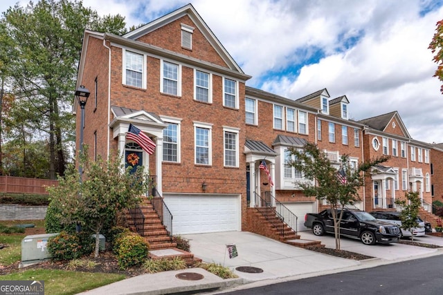 multi unit property featuring a garage, driveway, and brick siding