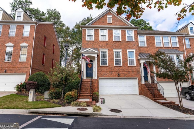 townhome / multi-family property featuring driveway, a garage, and brick siding