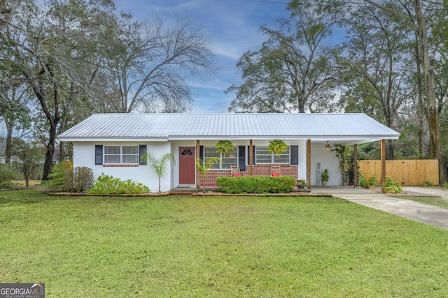 single story home featuring metal roof, brick siding, fence, driveway, and a front yard