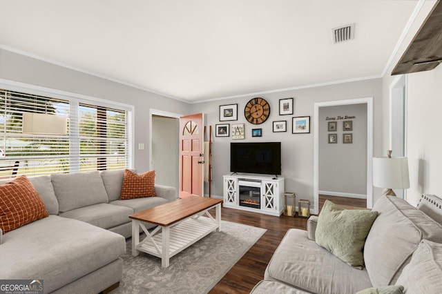 living room with baseboards, visible vents, dark wood-type flooring, and ornamental molding