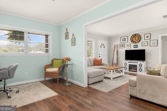 living area featuring dark wood-style floors, ornamental molding, visible vents, and baseboards