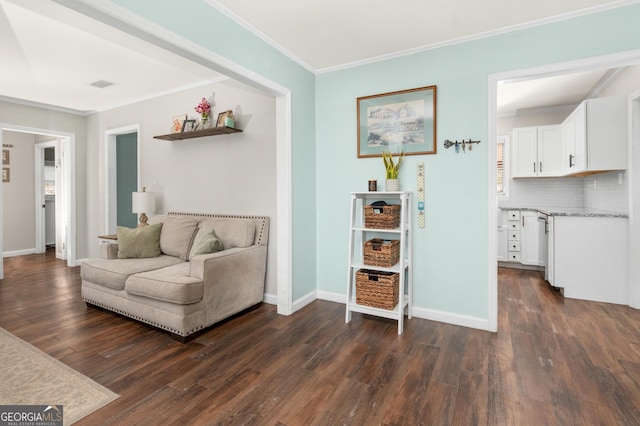 living area featuring dark wood-type flooring, visible vents, crown molding, and baseboards