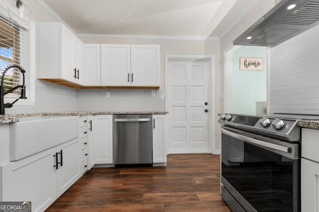 kitchen featuring white cabinets, dark wood-style floors, wall chimney exhaust hood, stainless steel appliances, and crown molding