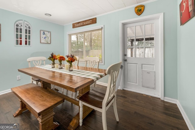 dining space featuring dark wood-style floors, baseboards, and crown molding