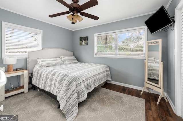 bedroom featuring a ceiling fan, crown molding, baseboards, and wood finished floors