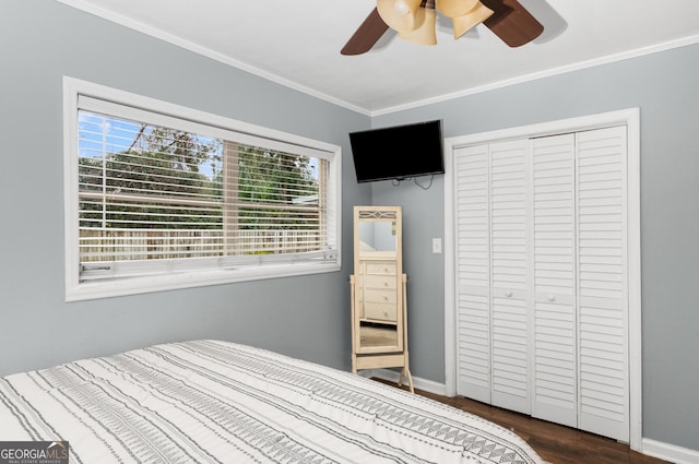 bedroom featuring dark wood-style floors, a closet, crown molding, and baseboards