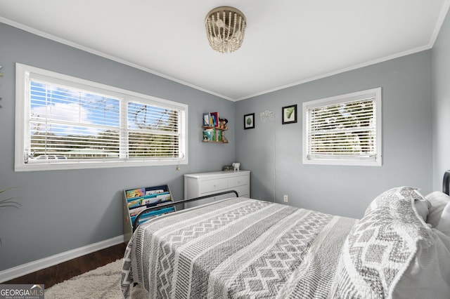 bedroom with ornamental molding, wood finished floors, and baseboards