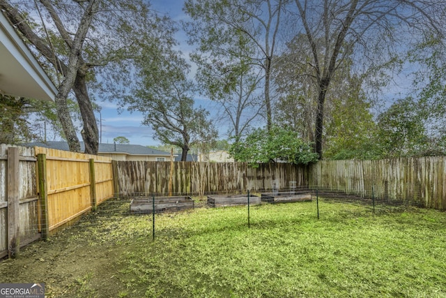 view of yard featuring a fenced backyard and a garden