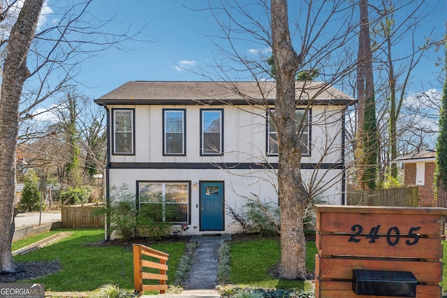 view of front of property featuring a front yard, brick siding, fence, and roof with shingles