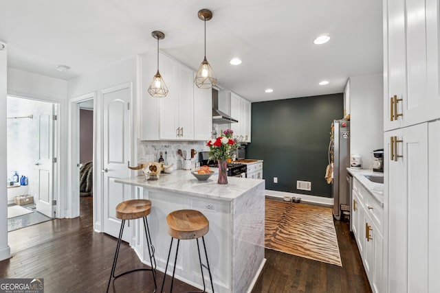 kitchen featuring a peninsula, white cabinetry, appliances with stainless steel finishes, dark wood-style floors, and tasteful backsplash