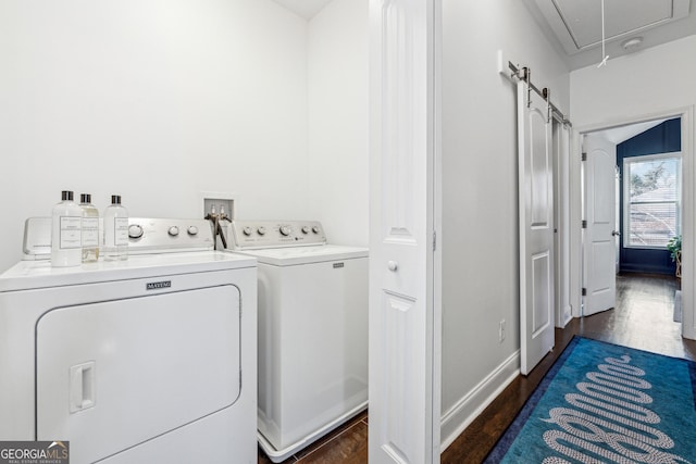 clothes washing area with washing machine and clothes dryer, attic access, wood finished floors, laundry area, and baseboards