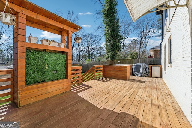 wooden terrace with a grill and fence