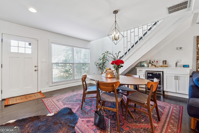 dining room with wine cooler, a notable chandelier, visible vents, stairway, and dark wood finished floors