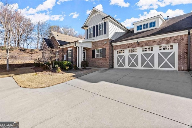 view of front of property featuring driveway, an attached garage, and brick siding