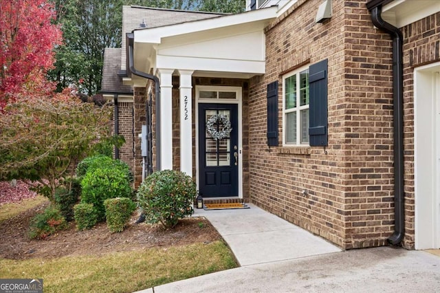 entrance to property featuring brick siding