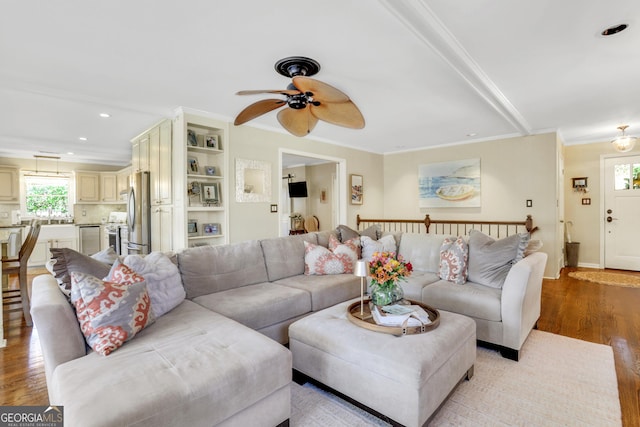 living room with light wood-type flooring, a ceiling fan, recessed lighting, crown molding, and baseboards