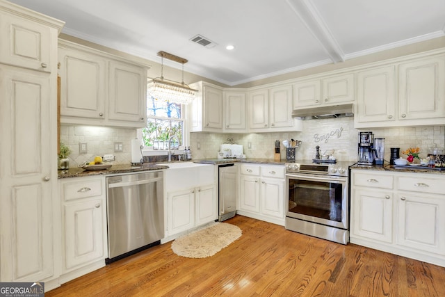 kitchen featuring visible vents, light wood-style flooring, under cabinet range hood, dark stone counters, and appliances with stainless steel finishes