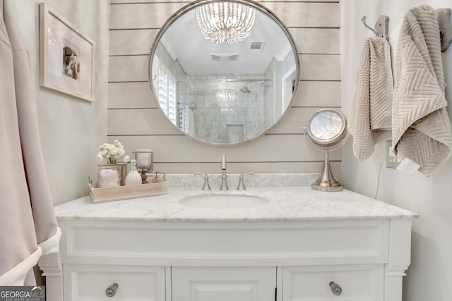 bathroom featuring vanity, a shower, and visible vents