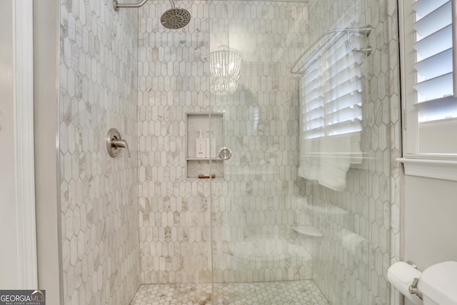 full bath featuring a wealth of natural light, toilet, and tiled shower