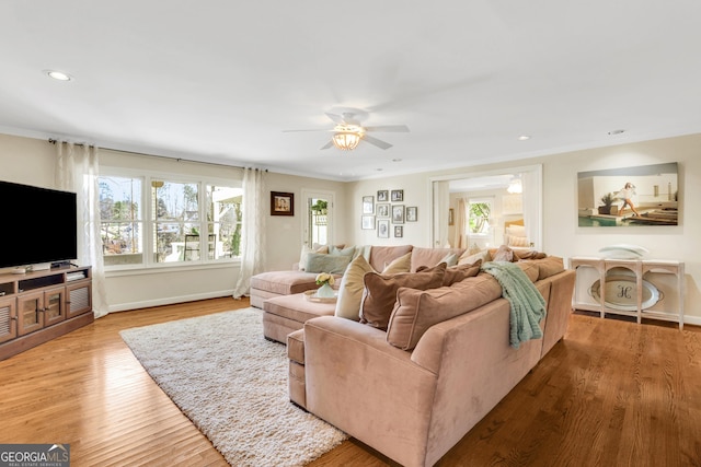 living room featuring recessed lighting, baseboards, a healthy amount of sunlight, and wood finished floors