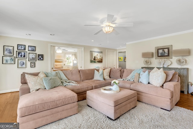 living room featuring ceiling fan, wood finished floors, baseboards, and ornamental molding