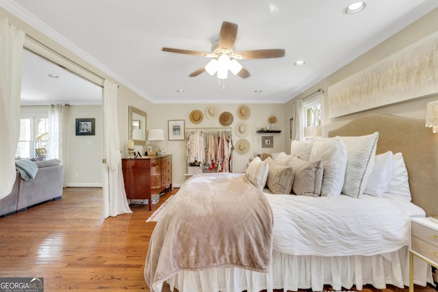 bedroom featuring multiple windows, wood finished floors, baseboards, and ornamental molding