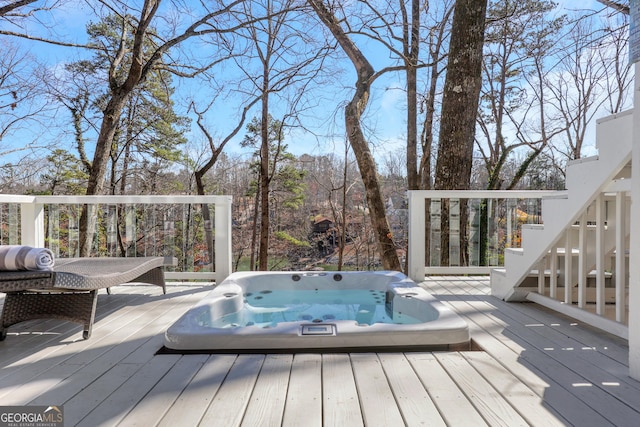 wooden terrace featuring hot tub deck surround