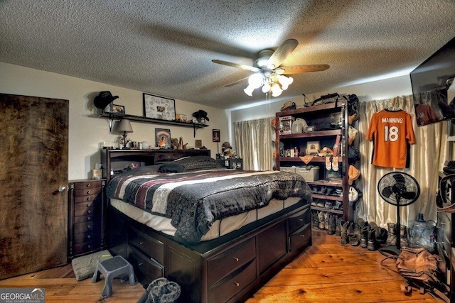 bedroom with ceiling fan, a textured ceiling, and hardwood / wood-style floors