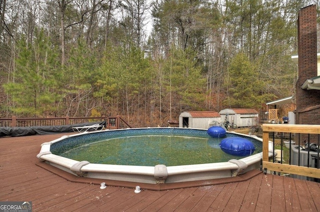 pool featuring a shed, an outdoor structure, and a wooden deck