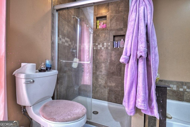 full bathroom with a shower stall and toilet