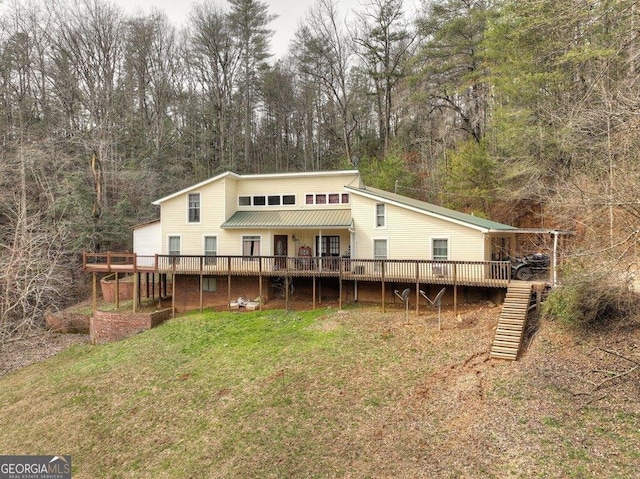 back of house with metal roof, a yard, a wooden deck, and stairs