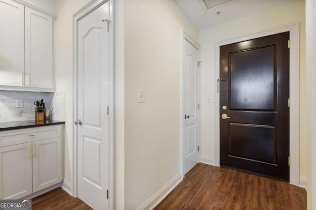 interior space featuring dark wood-style flooring and baseboards