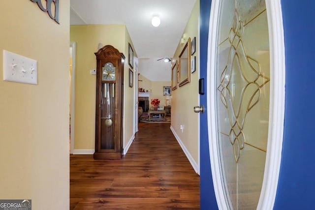 hall with baseboards and wood finished floors