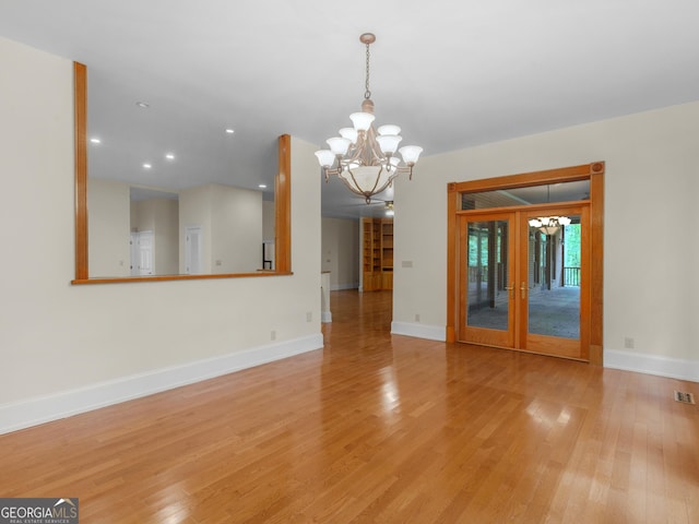 interior space featuring baseboards, light wood finished floors, recessed lighting, and a notable chandelier