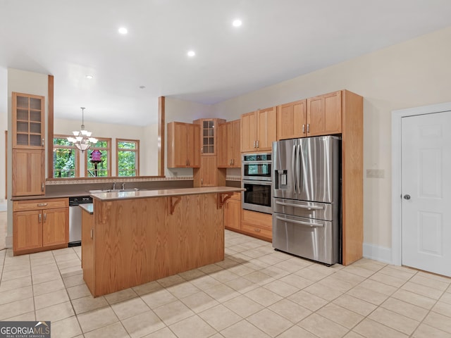 kitchen with a chandelier, light tile patterned floors, a breakfast bar, appliances with stainless steel finishes, and glass insert cabinets