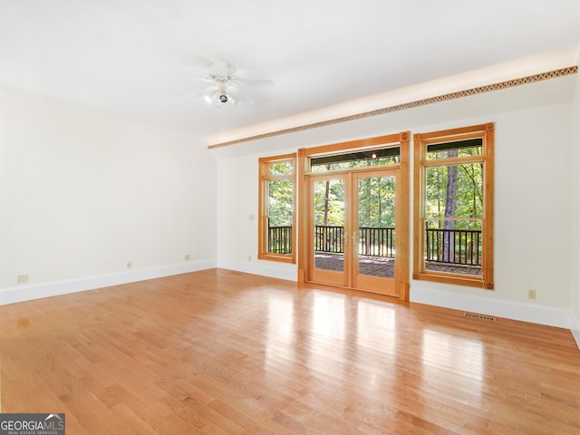 unfurnished living room featuring french doors, visible vents, a ceiling fan, light wood-type flooring, and baseboards