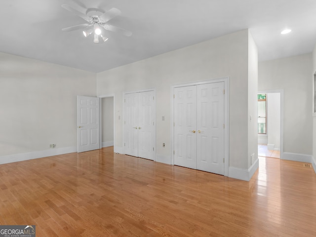 unfurnished bedroom featuring multiple closets, recessed lighting, ceiling fan, light wood-type flooring, and baseboards