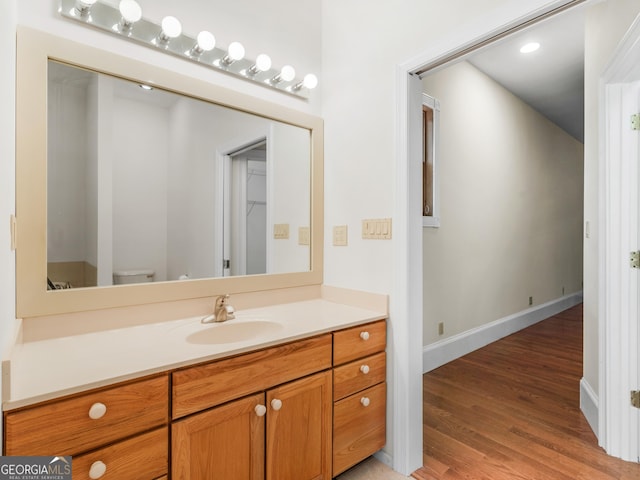 bathroom with vanity, baseboards, and wood finished floors