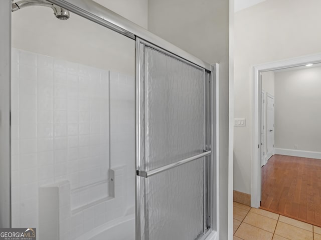 full bathroom featuring bath / shower combo with glass door, baseboards, and tile patterned floors