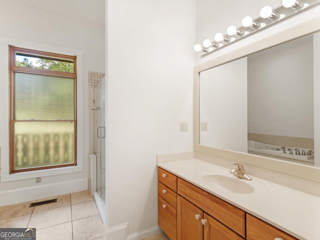 bathroom with a stall shower, visible vents, baseboards, tile patterned flooring, and vanity