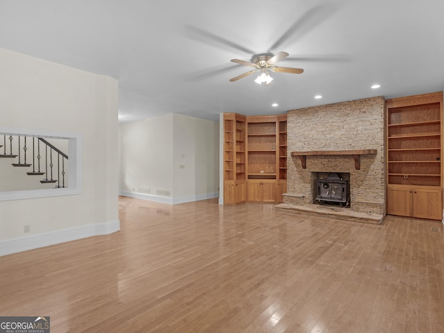 unfurnished living room with a ceiling fan, stairway, light wood-style flooring, and baseboards