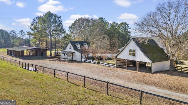 view of yard featuring dirt driveway, an outdoor structure, and an exterior structure