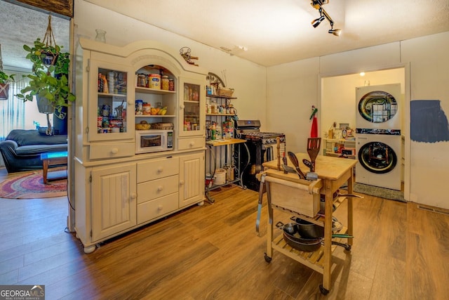 kitchen with washer / clothes dryer, white microwave, and light wood-style floors