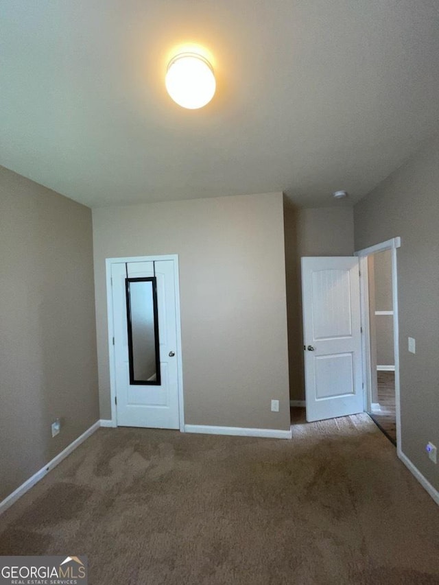 unfurnished bedroom featuring carpet and baseboards