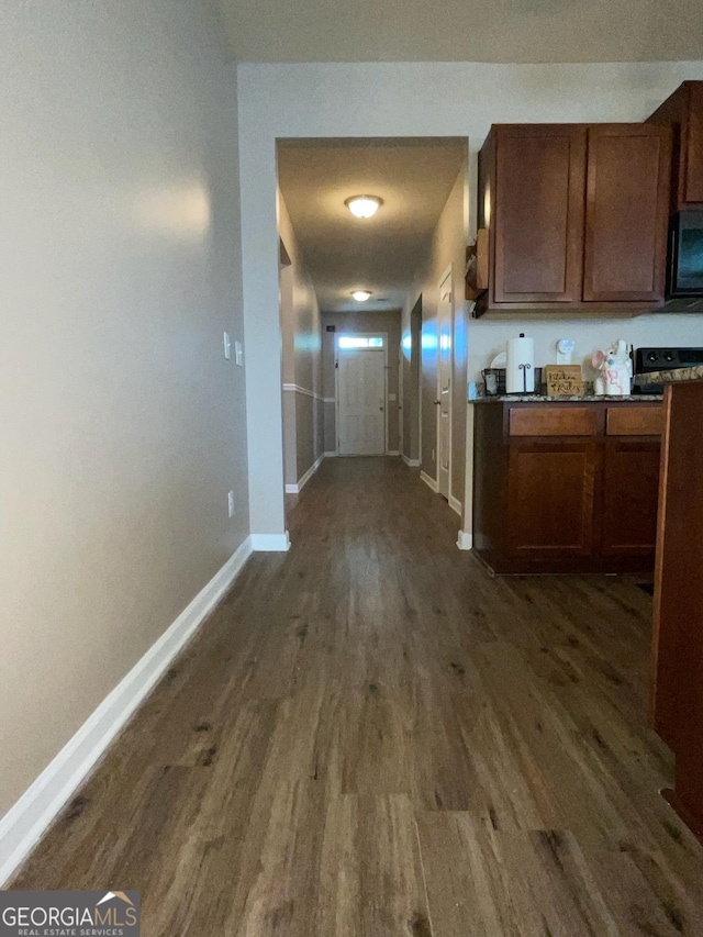 hall with dark wood-style floors and baseboards