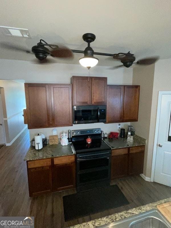 kitchen with electric range, dark countertops, dark wood finished floors, and visible vents